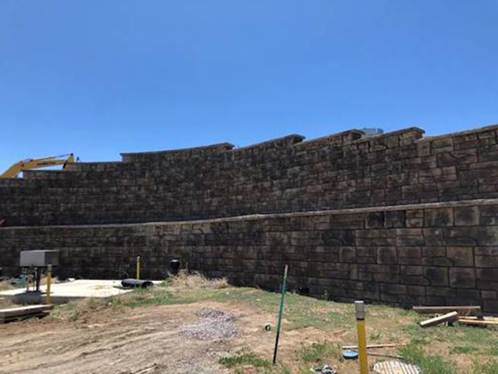 A large retaining wall made of Redi Rock Ledgestone in Aurora.